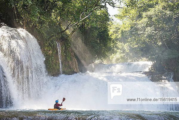 One man on his kayak below some waterfalls in Cascadas de Agua Azul  Chiapas  Mexico.