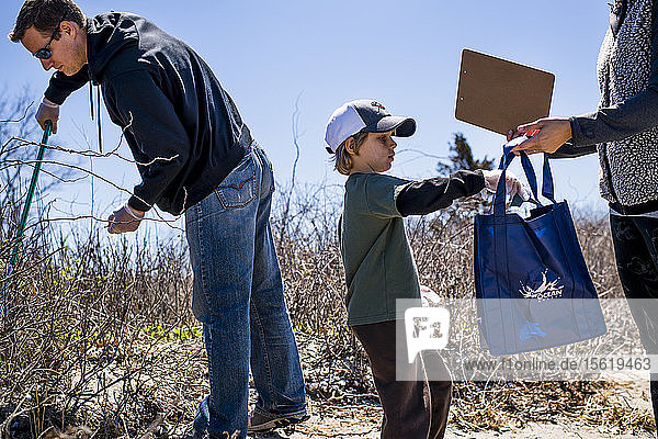 Familie sammelt Müll während der Strandsäuberung am Earth Day auf  Portsmouth  Rhode Island  USA