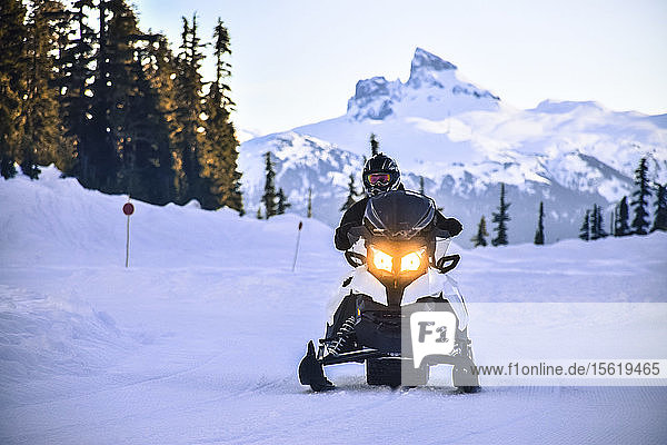 Front view shot of adventurous man riding snowmobile in Callaghan Valley  Whistler  British Columbia  Canada