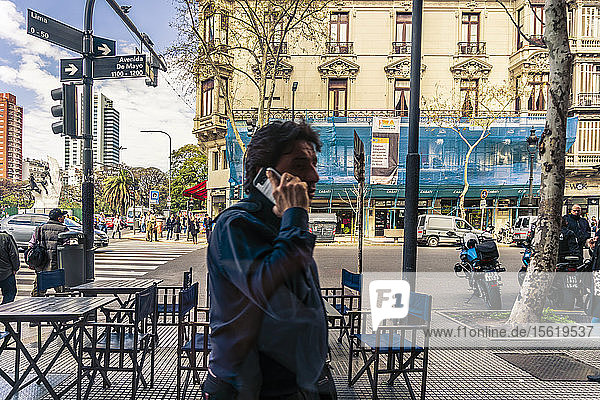 Mann geht auf der Straße und spricht am Telefon  Avenida de Mayo  Buenos Aires  Argentinien