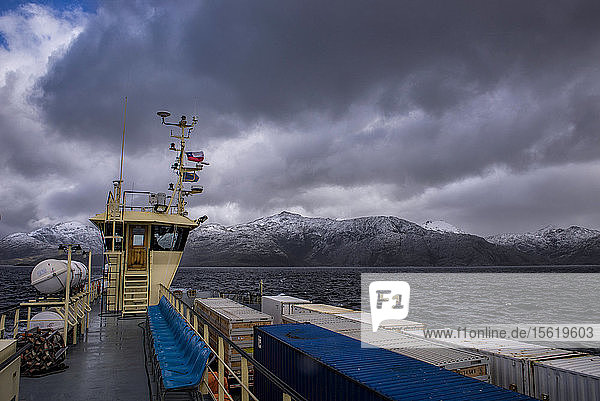 View with dramatic sky over sailing container ship Patagonia