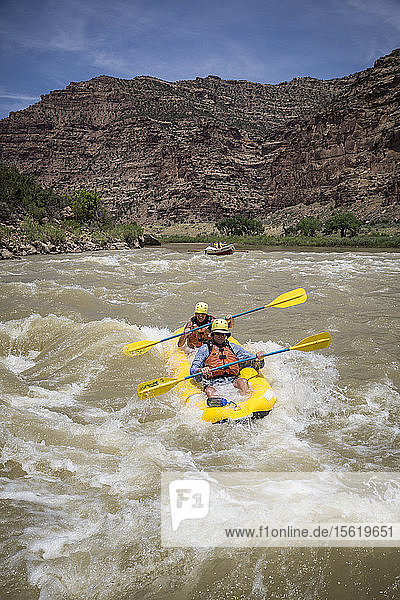 A man and woman paddling an inflatable kayak through rapids on a Green river rafting trip  Desolation/Gray Canyon section  Utah  USA