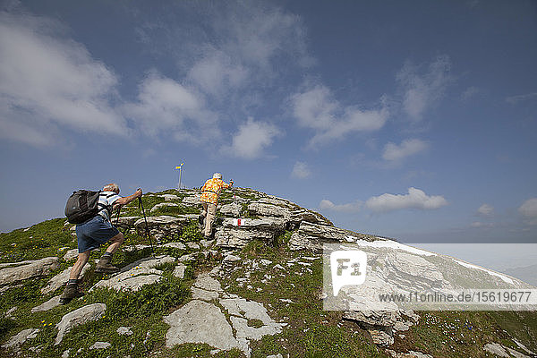 An unidentified couple hiking in the Toggenburg region of the Swiss Alps far above Lake Wallen.