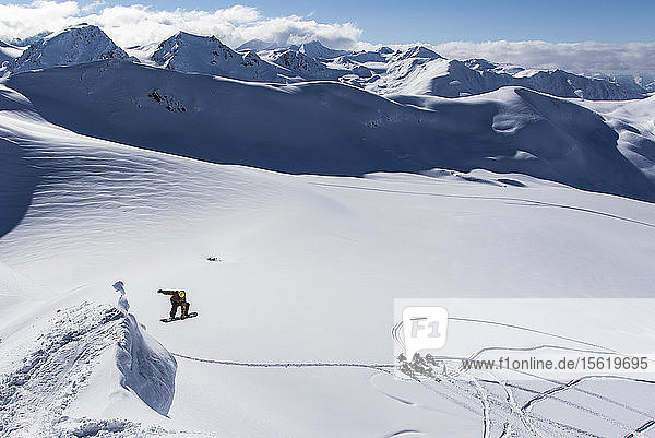 Snowboarder springt auf Snowboard im Norden von British Columbia