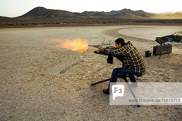 A man fires his revolver from a shooting stand in the High Sierras