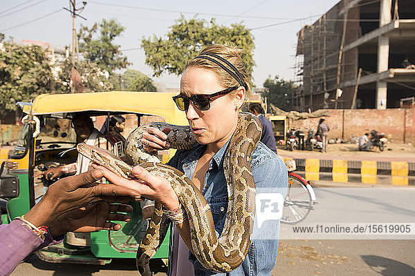 An American girl playing with a large snake in Agra  India.