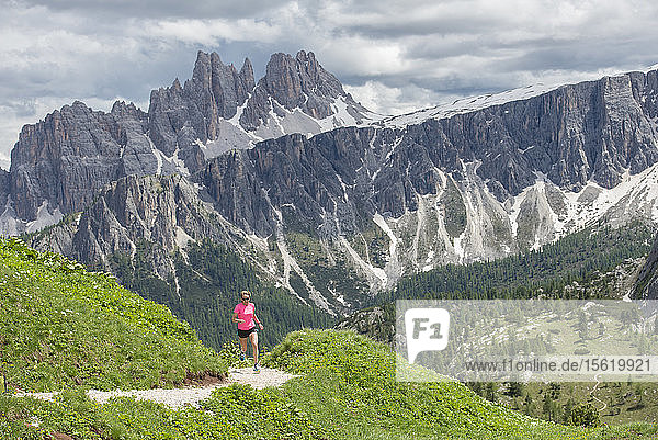 Eine Frau Trail Running bei den Cinque Torri Bereich mit der Croda Da Lago und Lastoi De Formin im Hintergrund