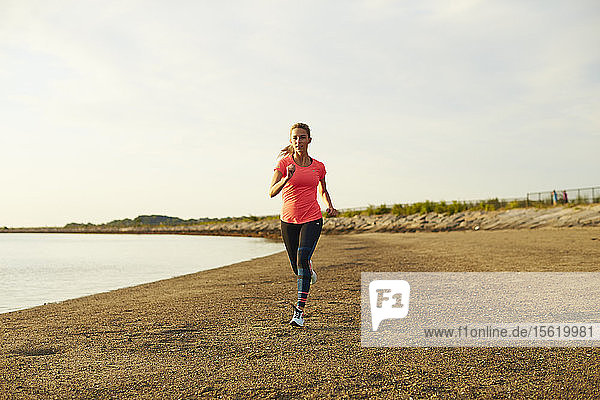 A Young Athletic Woman Running On Beach