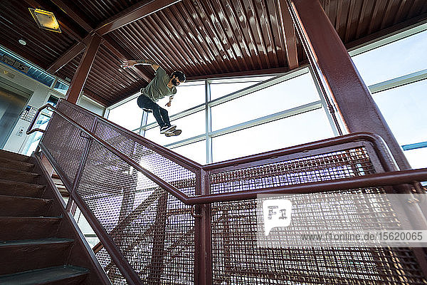 Männlicher Parkour-Sportler springt in der Luft über eine Treppe in der Stadt