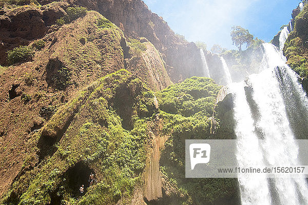 Two Boys Getting Ready To Jump From High Above The Water Next To Cascades Douzoud Waterfall
