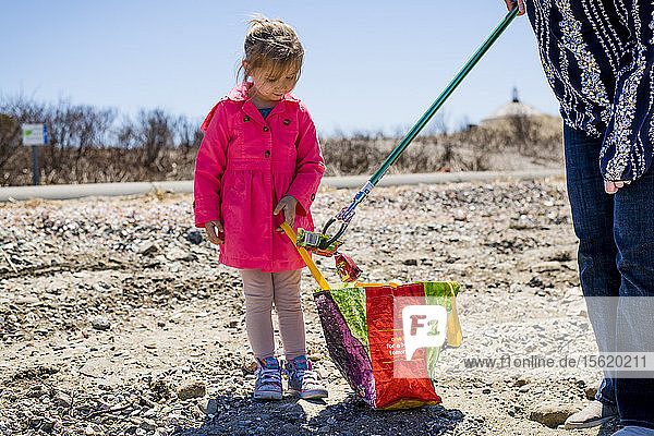 Mädchen und Erwachsener beim Aufsammeln von Müll während der Strandsäuberung am Earth Day  Portsmouth  Rhode Island  USA