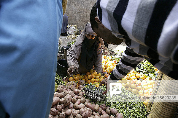 Eine Frau erntet Gemüse auf der Straße im Medina-Viertel von Marrakesch