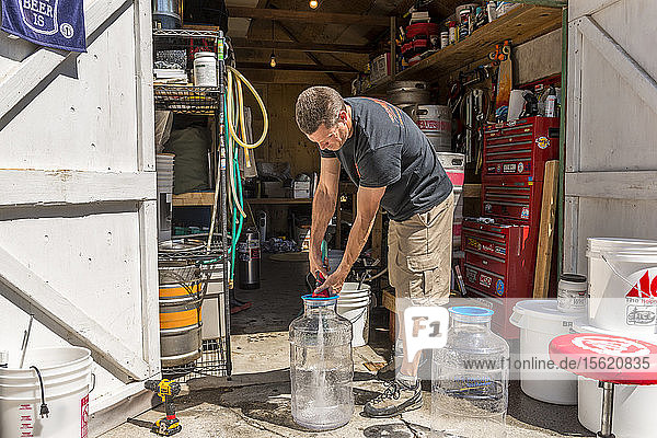Mann gießt Wasser für die Verwendung beim Heimbrauen von Bier  Boshop  Kalifornien  USA