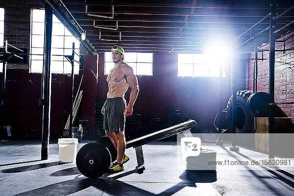 Ein Crossfit-Sportler ruht sich zwischen den Sätzen in einem alten  düsteren Fitnessstudio in San Diego  CA  aus.