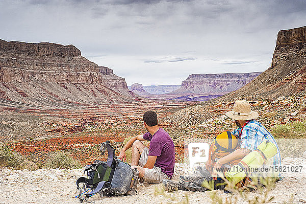 Two backpackers stare out into the Grand Canyon.