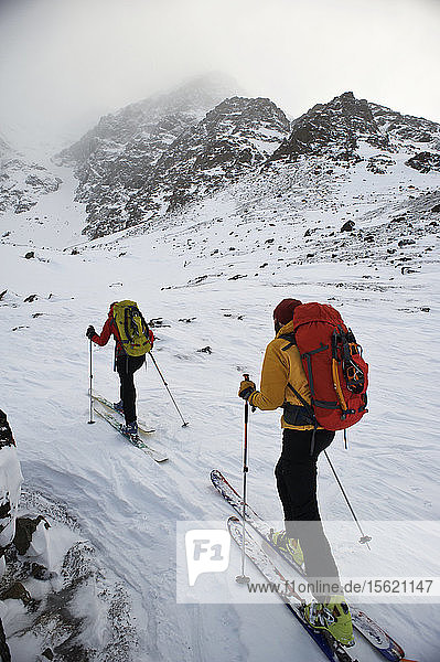 Climbers approach the North Face of Ptarmigan Peak (4 910 feet) on skis during a stormy day in Chugach State Park  near Anchorage  Alaska February 2011. (Model Release: Agnes Hage  Kyle Irwin)