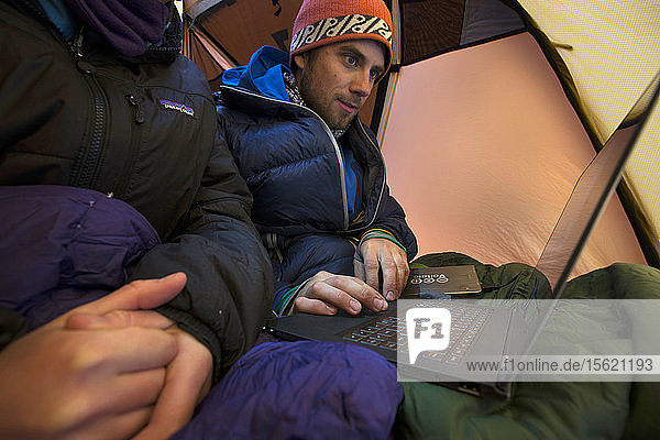 Zwei Personen sitzen in einem aufgestellten Zelt mit Laptop  New Hampshire  USA