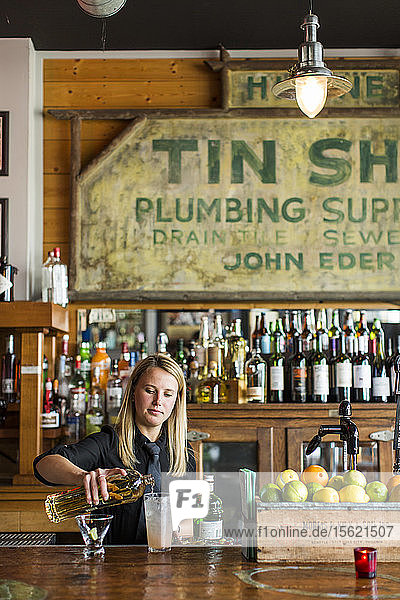 Female bartender preparing tequila cocktail at bar  Seattle  Washington  USA