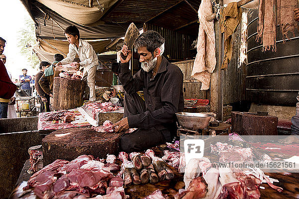 Ein Straßenhändler schneidet Fleisch in Jaipur  Indien.