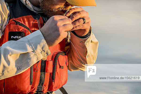 Fisherman ties on another lure at sunset