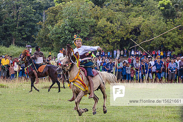 Männer reiten auf Pferden und werfen einen Speer beim Pasola-Festival  Insel Sumba  Indonesien
