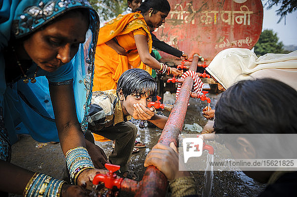 Menschen trinken Wasser während eines Festes in Uttar Pradesh  Indien.