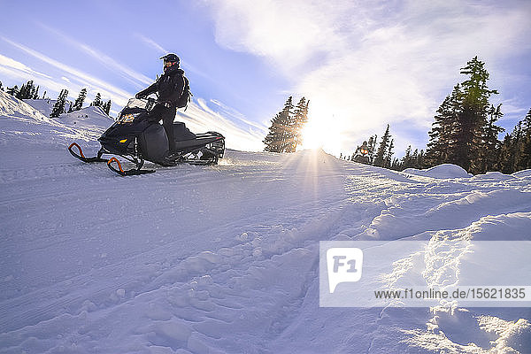 Seitenansicht eines abenteuerlustigen Mannes beim Schneemobilfahren im Callaghan Valley  Whistler  British Columbia  Kanada