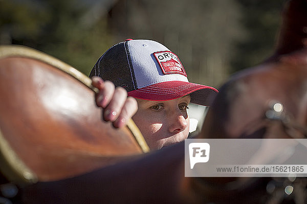 Eine Frau bereitet sich auf das Aufsitzen auf einem Pferd vor  während sie auf einer Gastranch in Montana reitet.