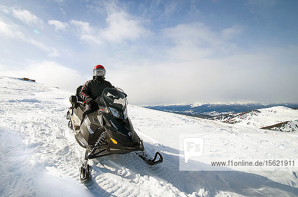 Mann auf Schneemobil auf dem Gipfel eines Berges  Vail  Colorado