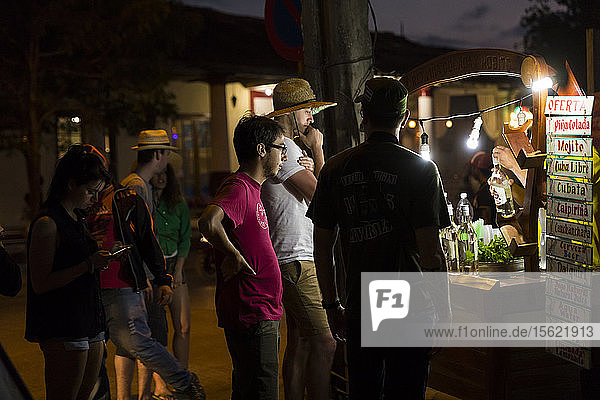 Eine Gruppe von Touristen steht vor einer Straßenbar in Vinales  Kuba  bei Nacht