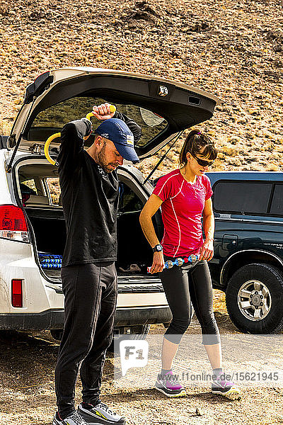 Man and woman stretching after a trail run in the owens valley