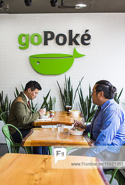 Foto von zwei männlichen Kunden in einem Restaurant  die Poke  ein traditionelles hawaiianisches Gericht  essen  Seattle  Washington State  USA