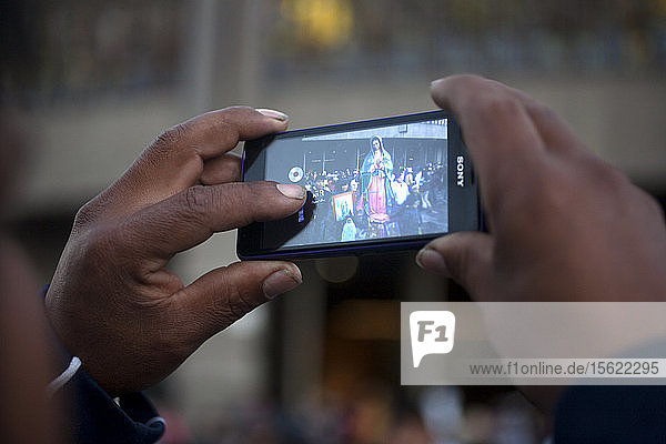 A man takes a picture of pilgrims during the annual pilgrimage to the Basilica of Our Lady of Guadalupe  Tepeyac Hill  Mexico City  Mexico. Guadalupe is known for indigenous as Tonantzin  that means Our Mother in Mexican nahuatl language. Millions arrive every year to the pilgrimage.