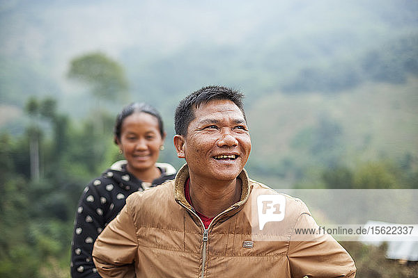 Ein junges Paar steht freudestrahlend vor dem künftigen provisorischen Standort seines Hauses oberhalb von Muang Va  Laos. Das Dorf wird durch den Staudamm Nr. 6 des Nam Ou-Flusses vollständig überflutet werden  und die von der Regierung vorgesehene Umsiedlung in der Nähe von Hat Sa wird nicht rechtzeitig abgeschlossen sein.