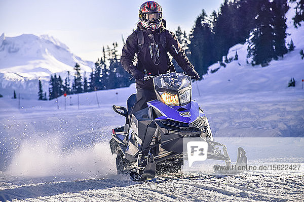 Front view shot of adventurous man riding snowmobile in Callaghan Valley  Whistler  British Columbia  Canada