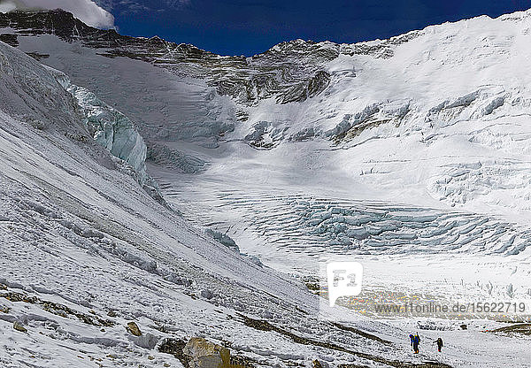Climbers make their way up toward the West Ridge Headwall from Camp 2 / Advanced Basecamp on Mount Everest. Lhotse and Nuptse are visible behind.