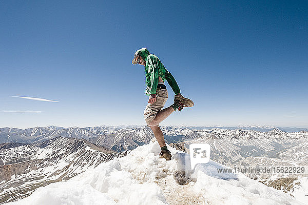 Side view shot of single male hiker stretching on mountain peak  La Plata Mountains  Colorado  USA