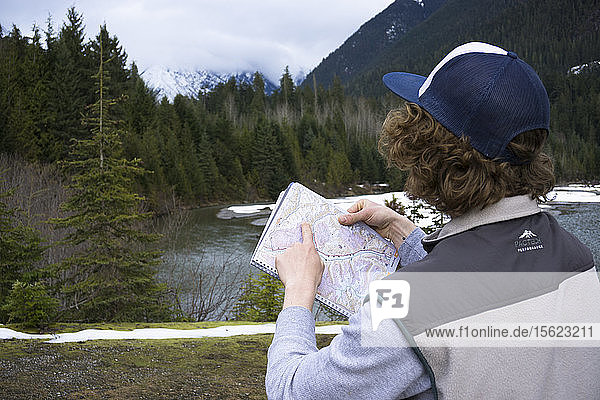 Mann  der eine Karte betrachtet  um den Standort und die Berggipfel zu bestimmen