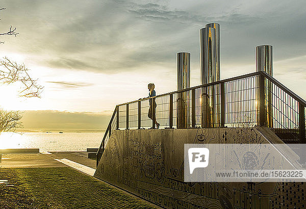 Female runner taking break near urban sculpture in downtown Seattle Washington State USA
