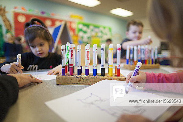 Group of schoolchildren coloring in classroom
