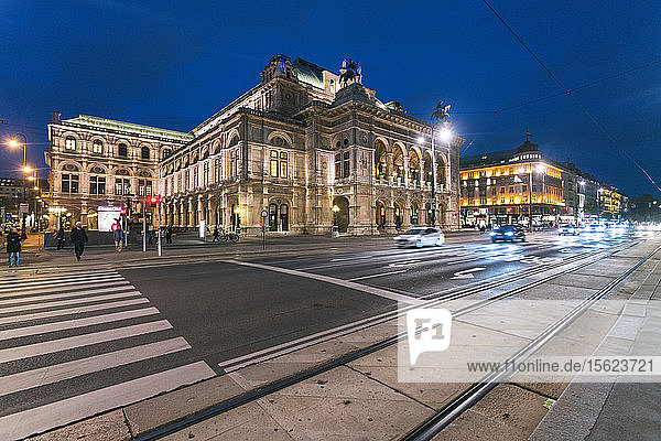 Illuminated exterior of Vienna State Opera across street at night  Vienna  Austria