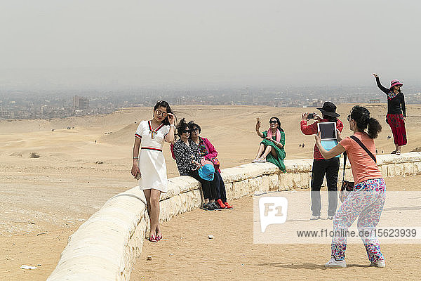 Weibliche Touristen posieren und fotografieren im Pyramidenkomplex von Gizeh  Kairo  Ägypten