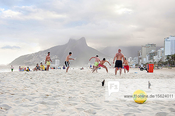 Gruppe von Männern spielen Fußball am Strand von Ipanema