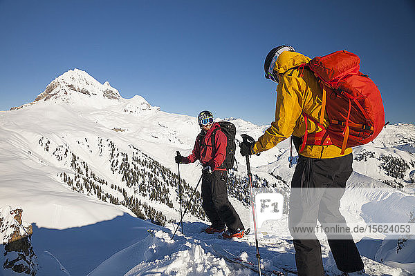Two Skiers On The Summit Of Mountain Near Elfin Lakes In Garibaldi Provincial Park  Canada