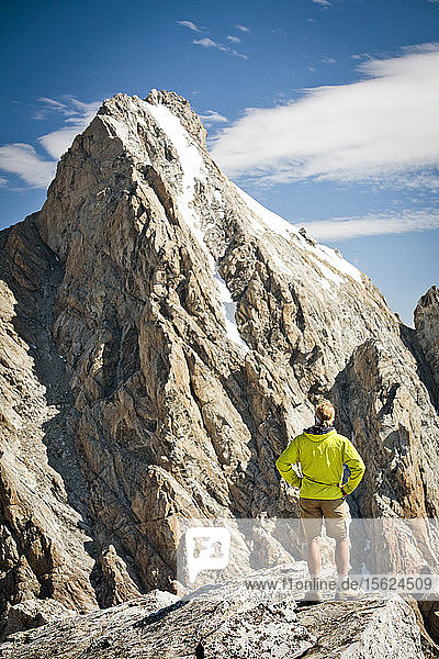 Ein Wanderer  der auf einem Felsen steht und auf den Grand Teton im Grand Teton National Park starrt