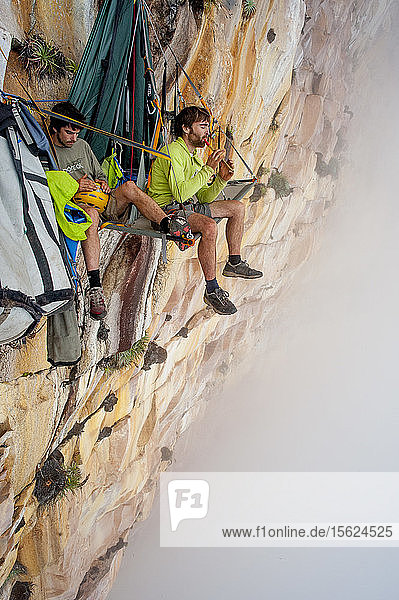 Zwei männliche Bergsteiger beim Musizieren auf dem Portaledge bei der Venezuela-Expedition