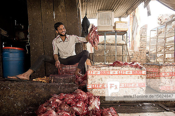 Ein junger indischer Mann schlachtet Hühner am Straßenrand in Jaipur  Indien.