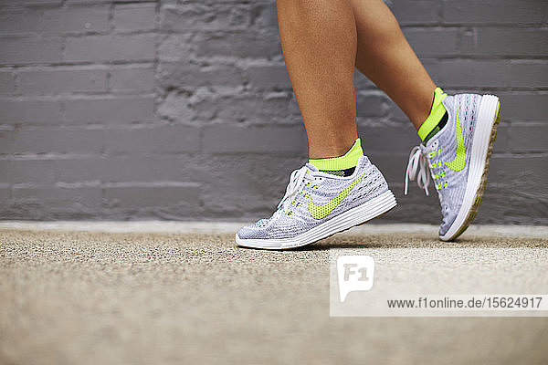 Close-up Of Woman's Running Shoes Against Wall