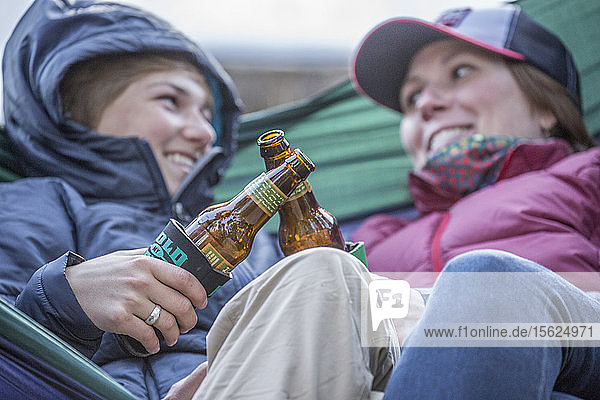 Two girls with beer in a hammock in Montana.