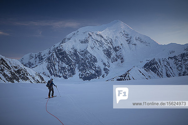 A ski mountaineer on the lower Kahiltna glacier of Denali National Park in Alaska  with mount Foraker in the background.
